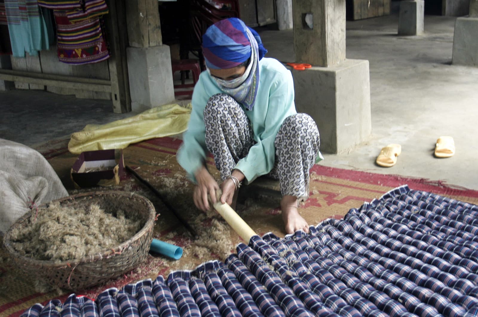 A woman stuffing a matress (like those we slept on -- comfy!) (4114637327)